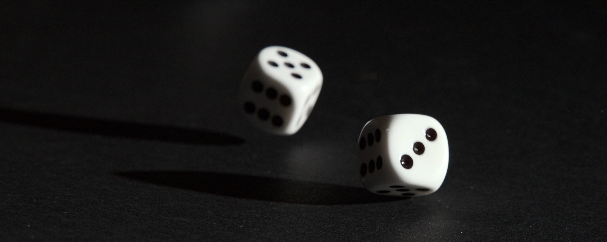 Two die mid-roll are positioned against a black background